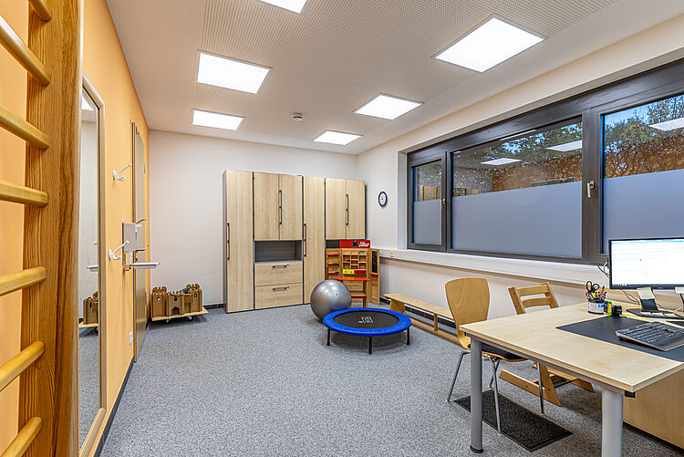 Ergotherapieraum mit Sportgeräten und Arbeitsplatz