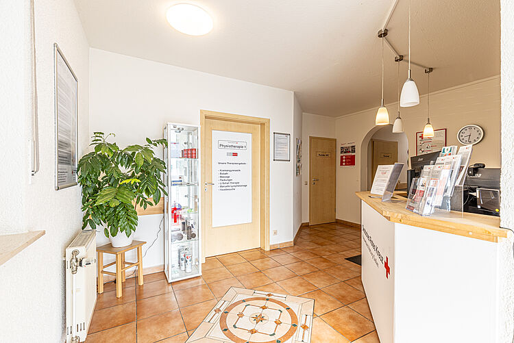 Empfang mit Tresen, Pflanzen und Infomaterialien in der DRK-Therapiepraxis