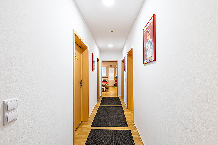 Flur mit Türen und Wandbildern in der DRK Therapiepraxis Alten-Buseck