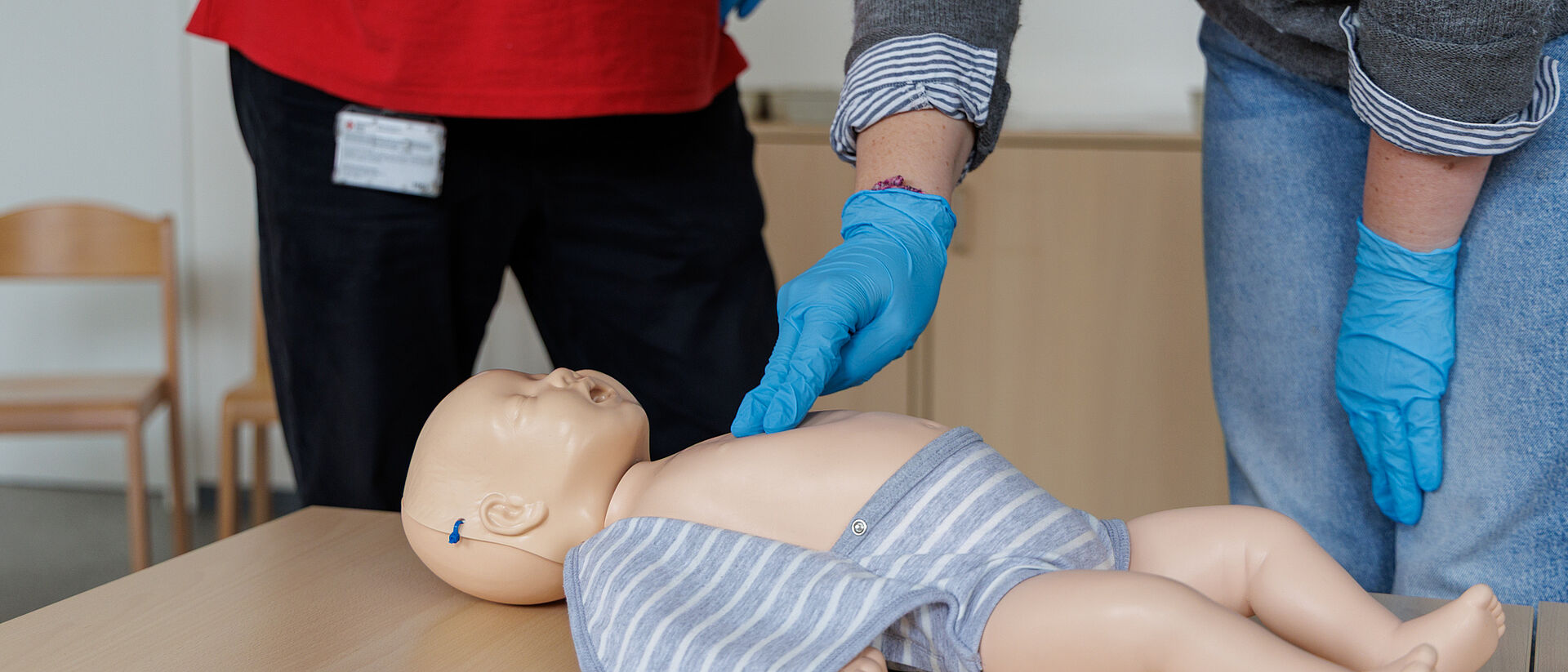 Reanimation an Säuglingspuppe wird im Erste Hilfe am Kind Kurs geübt