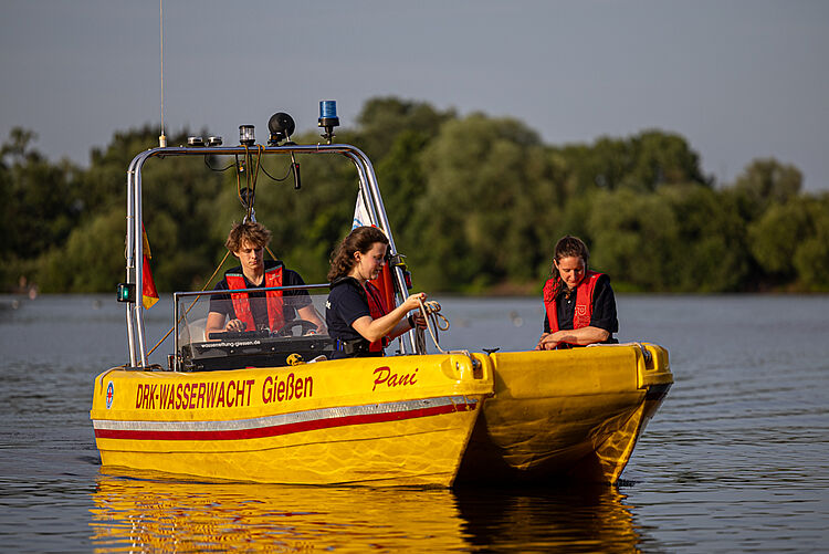 Ehrenamtliche der DRK Wasserwacht Gießen auf einem gelben Rettungsboot