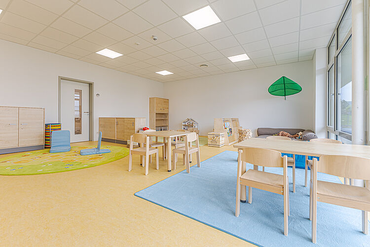 Gruppenraum mit Spielteppich und Sitzbereich