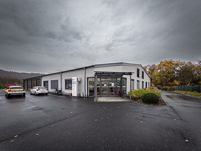 Bildungszentrum des Deutschen Roten Kreuzes in Marburg mit grünem Hauptgebäude und rotem Kreuz