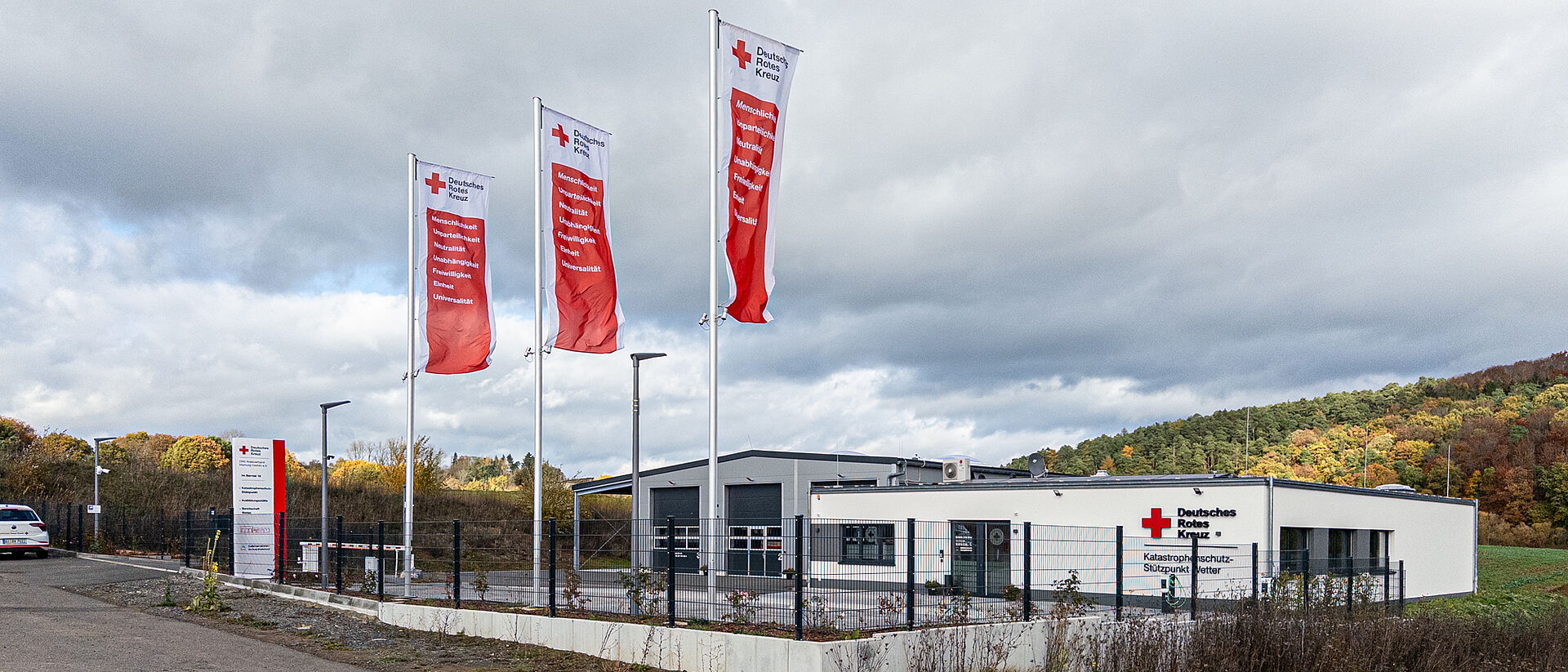 DRK-Stützpunkt Wetter bei Nacht mit rot beleuchtetem Gebäude und DRK-Logo