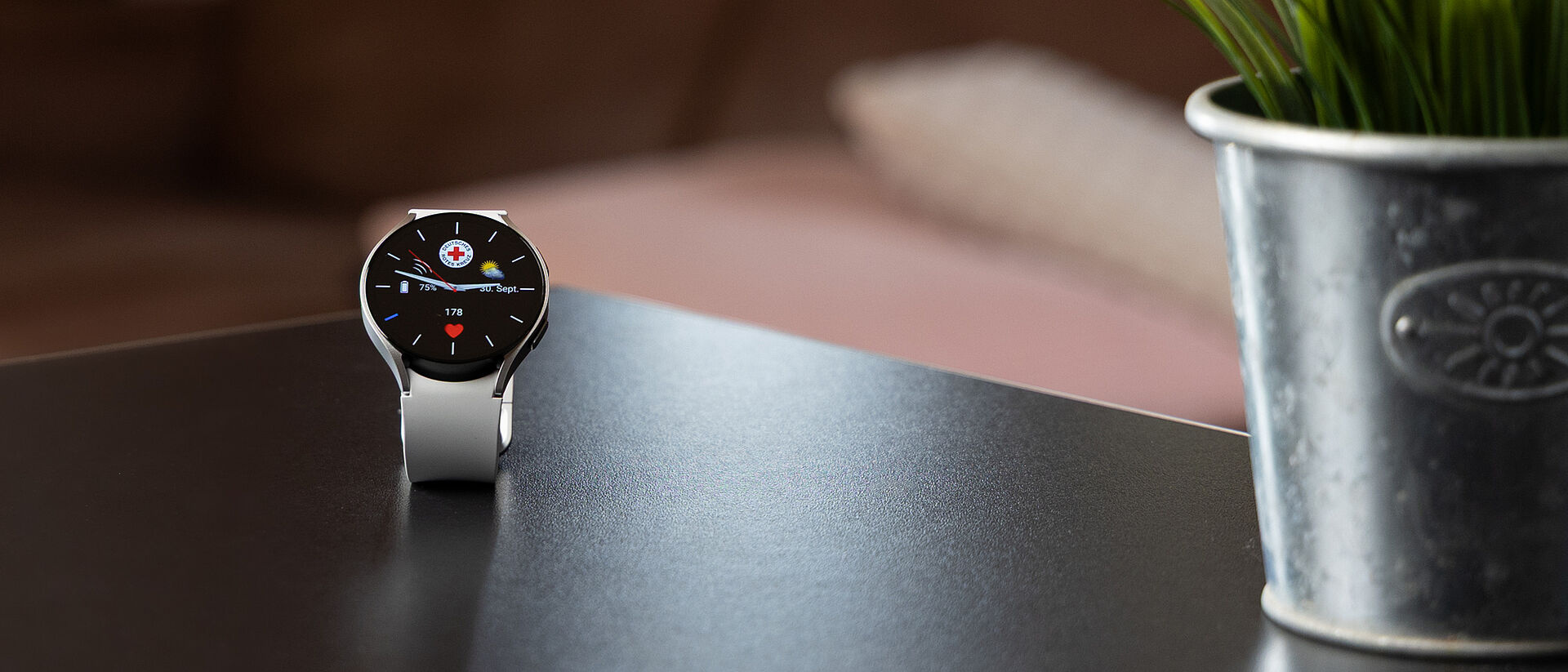 Moderne Notrufuhr mit DRK-Logo auf einem Tisch