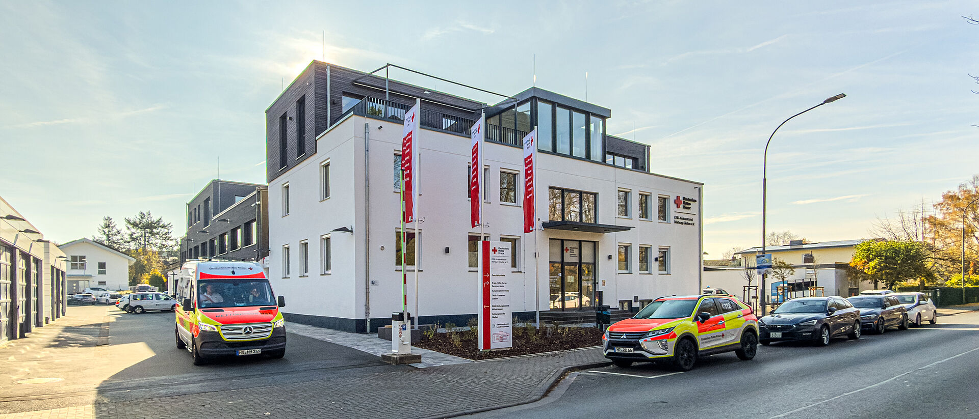 Gebäude des DRK Kreisverbands Marburg-Gießen in der Eichgärtenallee mit DRK-Fahnen und geparkten Einsatzfahrzeugen