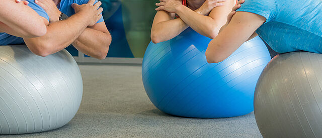 Teilnehmende beim Wirbelsäulentraining auf Gymnastikbällen in der DRK-Therapiepraxis
