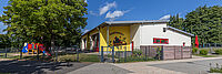 Außenansicht der DRK-Kita „Rabennest“ in Rabenau-Londorf mit Spielplatz und Kita-Gebäude bei sonnigem Wetter