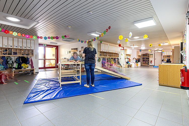 Kinder spielen im Flur der DRK-Kita „Rabennest“ in Rabenau-Londorf auf Matten und Bewegungsgeräten