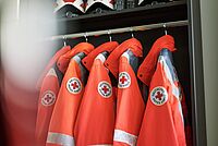DRK-Jacken und Helme ordentlich in Spind aufgehängt