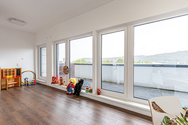 Spielbereich mit Holzspielzeug und großen Fenstern in der DRK-Therapiepraxis Marburg-Cappel