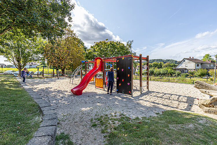 Spielplatz mit Rutsche und Kletterelementen im Garten der Kita