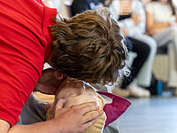 Schüler übt Mund-zu-Mund-Beatmung an Reanimationspuppe