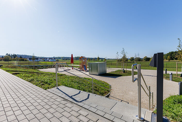 Treppe mit Geländer und Blick auf Spielplatz und Landschaft der Kita