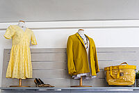 Secondhand-Mode im DRK-Kleiderladen Gießen: gelbes Kleid, Blazer und Tasche