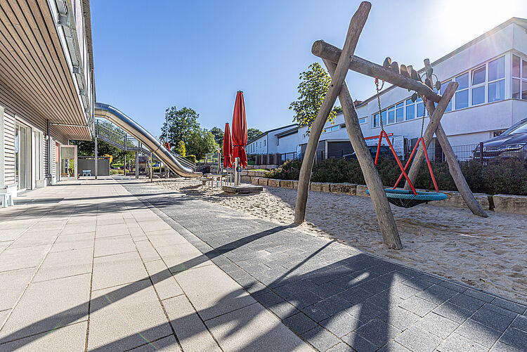 Holzschaukel mit Netzsitz auf dem Spielplatz der DRK-Kita „Henrys kleine Forscher“