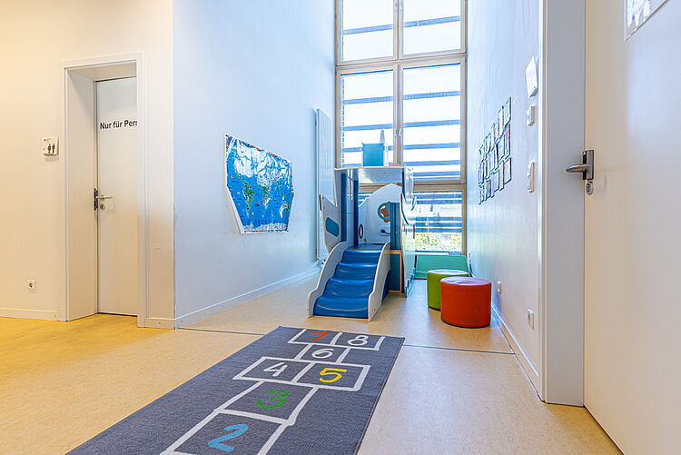 Indoor-Spielbereich mit Rutsche und Spielteppich in der DRK-Kita Staufenberg-Daubringen