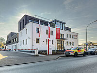 Gebäude des DRK Kreisverbands Marburg-Gießen in der Eichgärtenallee mit DRK-Fahnen und geparkten Einsatzfahrzeugen