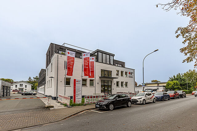 Gebäude des DRK Kreisverbands Marburg-Gießen in der Eichgärtenallee mit DRK-Fahnen und geparkten Einsatzfahrzeugen