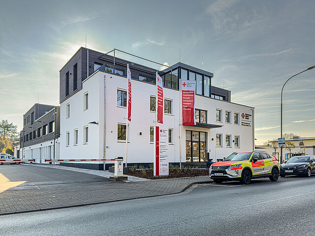 Gebäude des DRK Kreisverbands Marburg-Gießen in der Eichgärtenallee mit DRK-Fahnen und geparkten Einsatzfahrzeugen