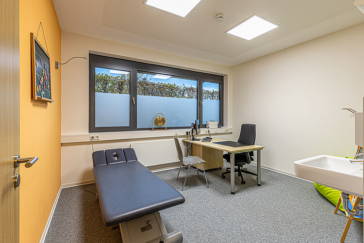 Heller Behandlungsraum mit Liege und Arbeitsplatz in der DRK Ergotherapie Stadtallendorf