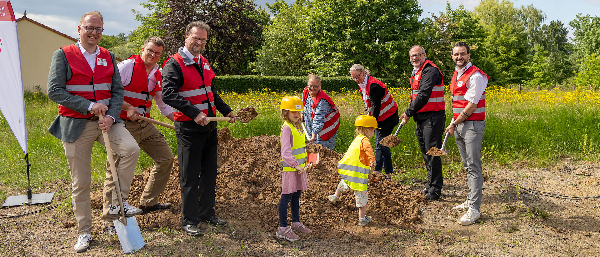 Spatenstich für neues DRK-Projekt in Mittelhessen Vertreter des DRK Mittelhessen beim symbolischen Spatenstich mit Kindern auf einer Wiese