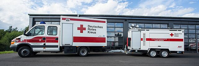 Einsatzfahrzeug und Anhänger der DRK-Betreuungseinheit Hessen vor Fahrzeughalle