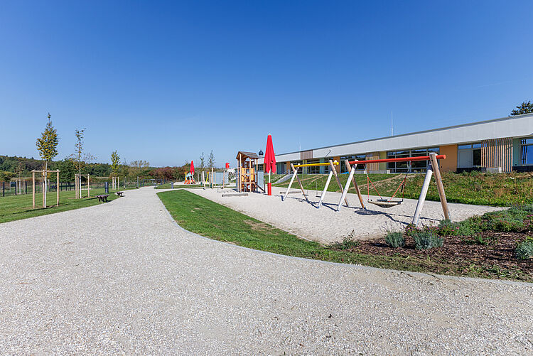Weitläufiger Kita-Spielplatz mit Schaukeln, Spielturm und Außengelände