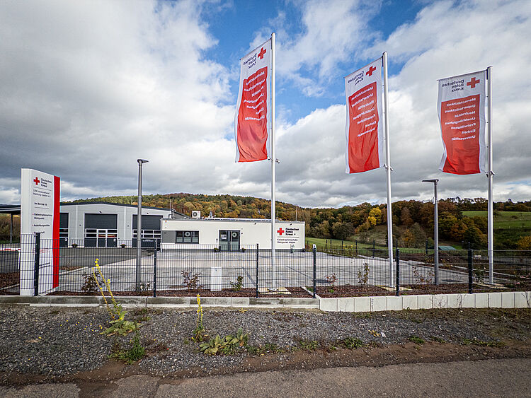 DRK-Stützpunkt Wetter bei Nacht mit rot beleuchtetem Gebäude und DRK-Logo