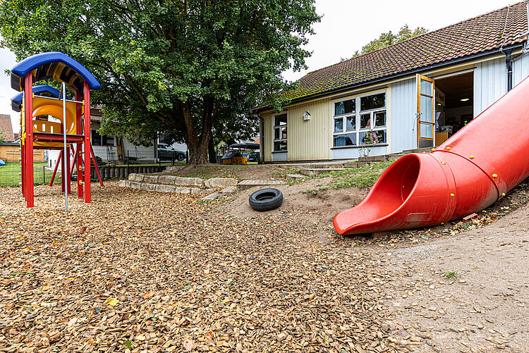 Rote Rutsche und Kletterturm im Garten der DRK-Kita Kunterbunt