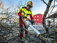 DRK-Mitarbeiter mit Bagger bei Erdarbeiten auf Grünfläche