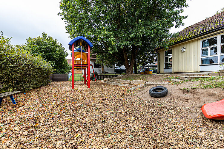 Bunter Kletterturm mit Rutsche und Schaukel im Garten der DRK-Kita Kunterbunt