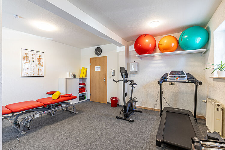 Raum mit Therapieliege, Gymnastikbällen, Ergometer und Laufband in der DRK-Therapiepraxis