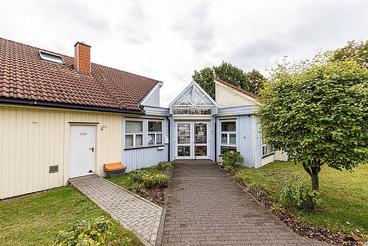Eingang der DRK-Kita Kunterbunt Rabenau-Rüddingshausen mit Weg und Garten