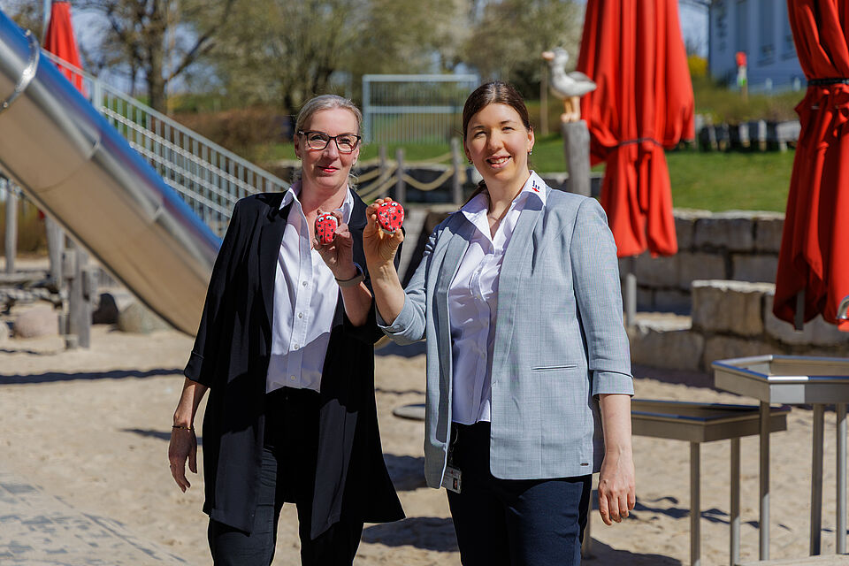 Birgit Theophel und Anna-Lena Tolomeo präsentieren bemalte Steine des Projekts „1000 Steine – 1000 Spuren der Menschlichkeit“ auf dem Außengelände der DRK Kita in Daubringen. Birgit Theophel und Anna-Lena Tolomeo präsentieren bemalte Steine des Projekts „1000 Steine – 1000 Spuren der Menschlichkeit“ auf dem Außengelände der DRK Kita in Daubringen.