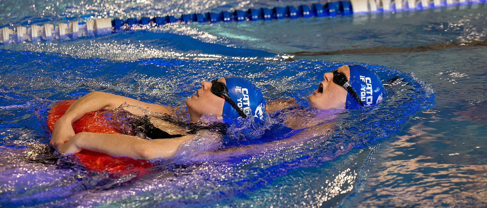 Zwei Teilnehmende beim DRK Rettungsschwimmer-Training mit Rettungsboje im Schwimmbad