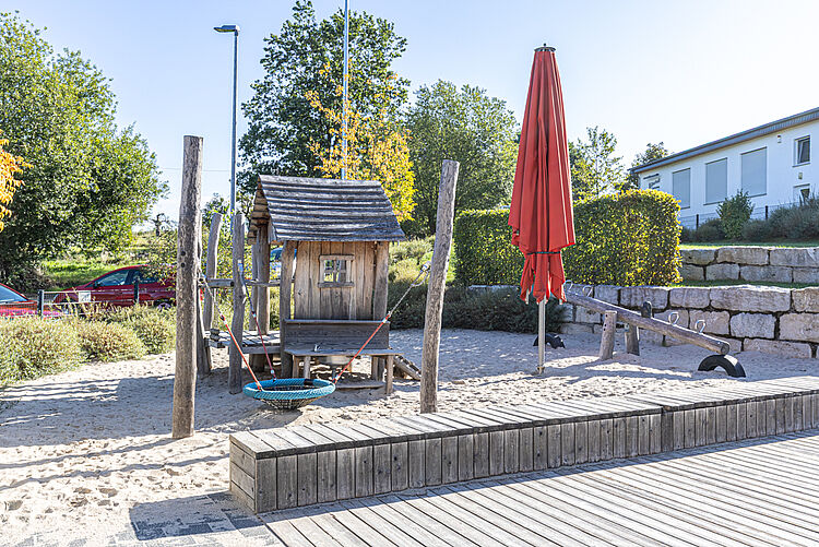 Außenbereich mit Sandkasten, Spielhaus und Schaukel in der DRK-Kita „Henrys kleine Forscher“