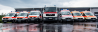 Einsatzfahrzeuge des Katastrophenschutzes des DRK Mittelhessen in Reihe vor einer Fahrzeughalle