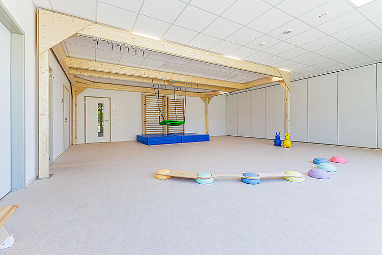 Großer Bewegungsraum mit Holzbalken, Schaukel, Sprossenwand und Balancierparcours