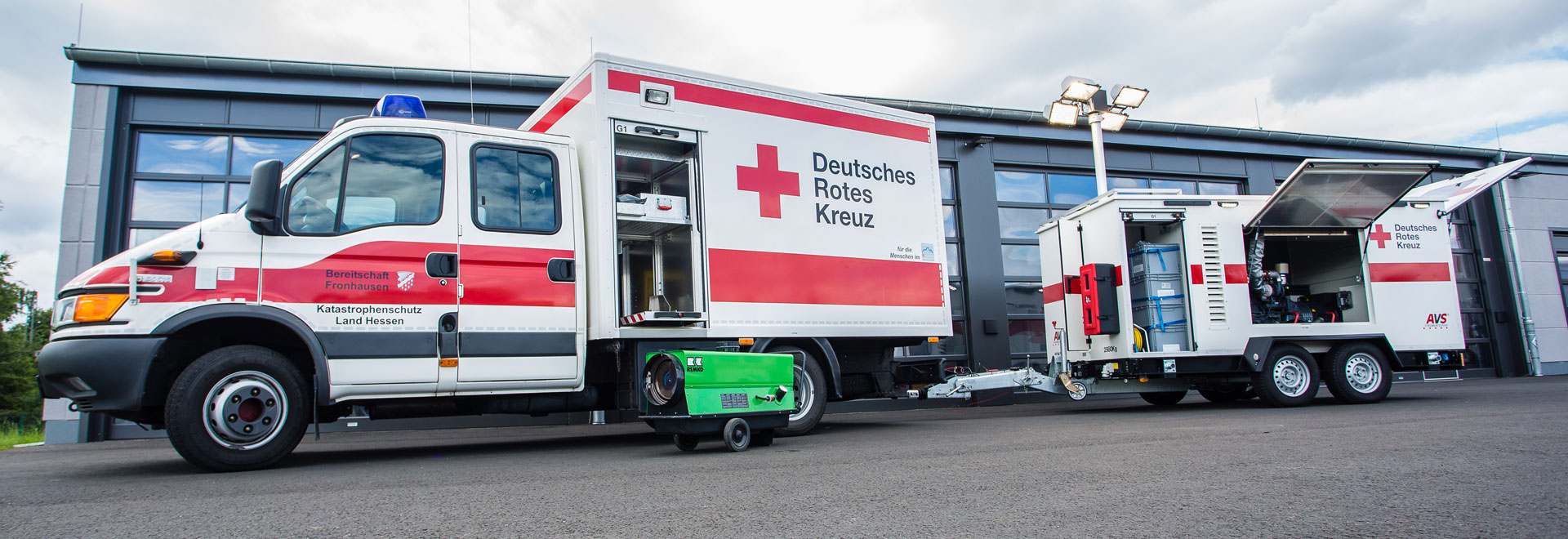 Einsatzfahrzeug und Anhänger der DRK-Betreuungseinheit Hessen vor Fahrzeughalle